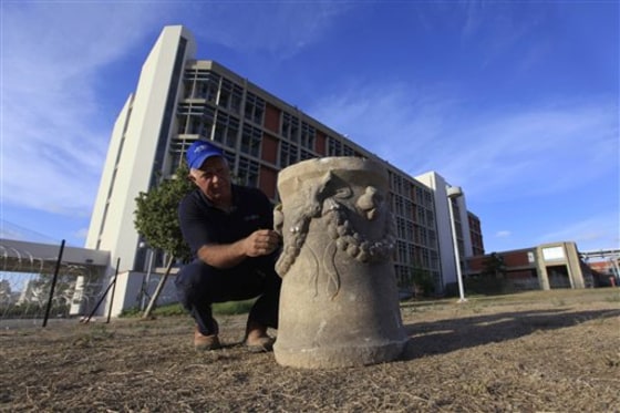 Dr. Yigal Israel of the Israeli antiquities authority inspects an ancient pagan altar that was uncovered in Ashkelon, Israel, Thursday, May 20, 2010.